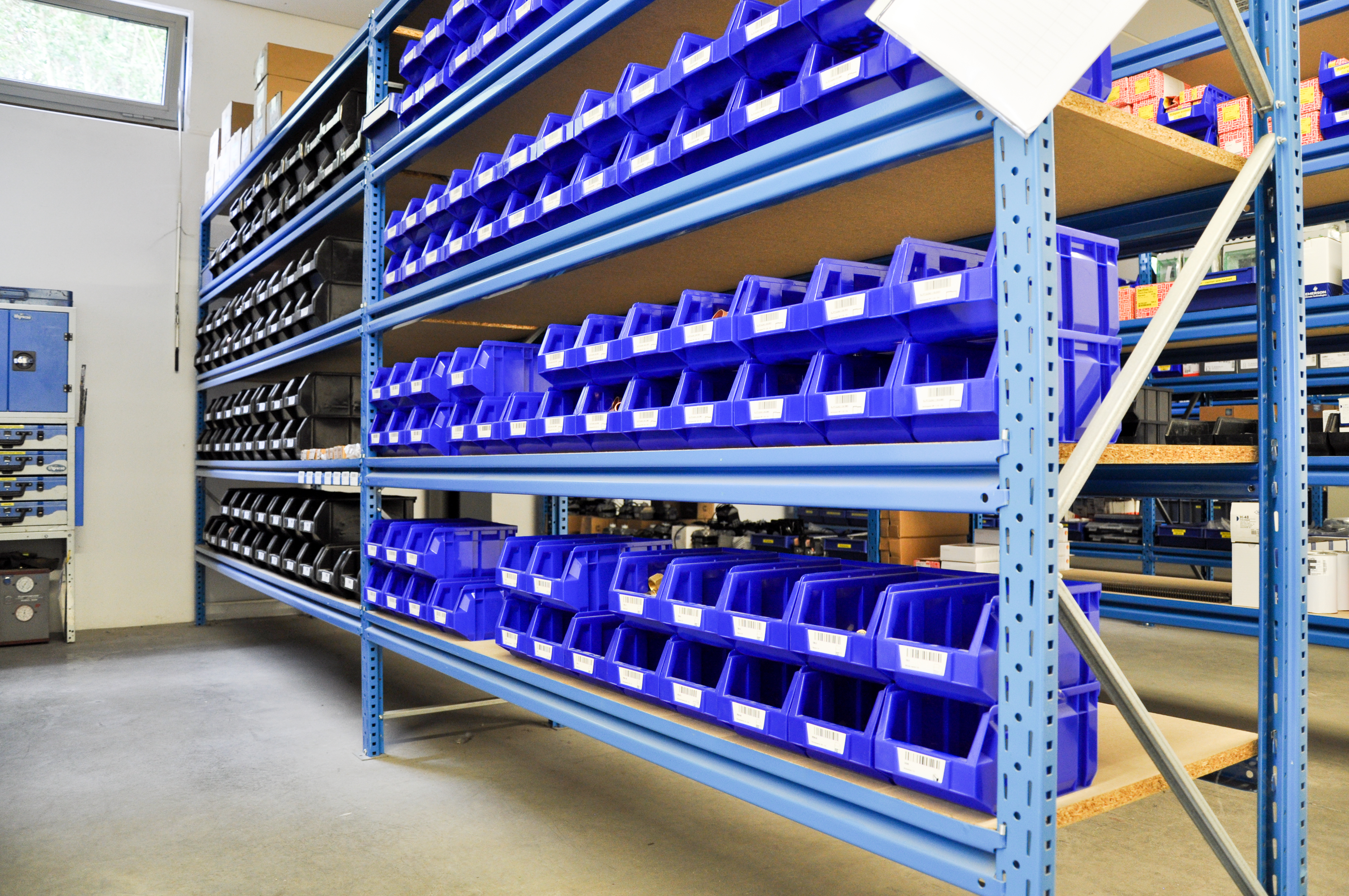 Magazijnrekken van AREC met gelabelde bakken vol wisselstukken
